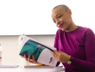 Employee alone in a meeting room in front of her laptop with notes sheets and water bottle