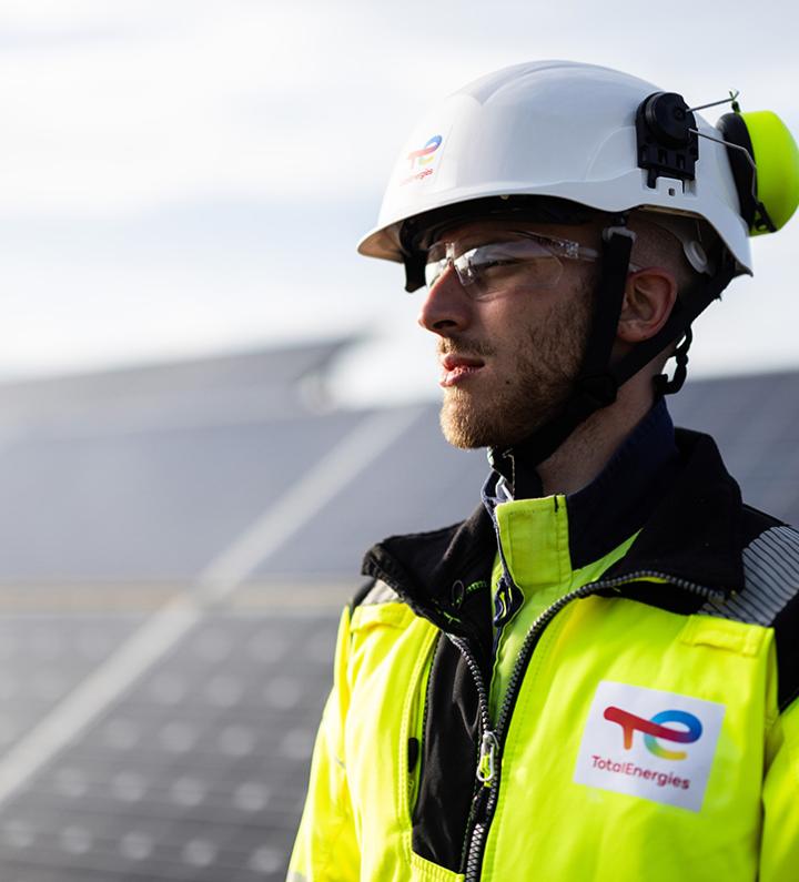 Operator wearing his PPE, in front of a solar panels