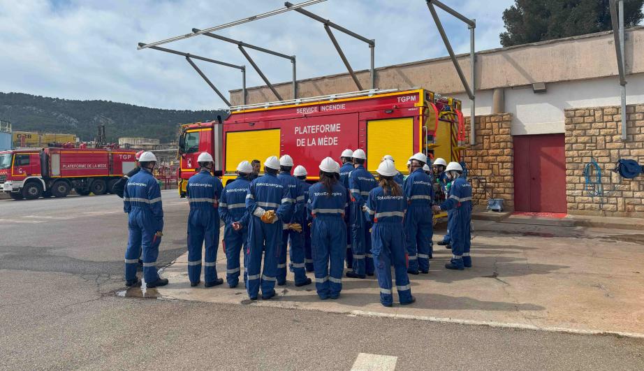 Group of people in work clothes, in an asphalt courtyard - see detailed description hereafter