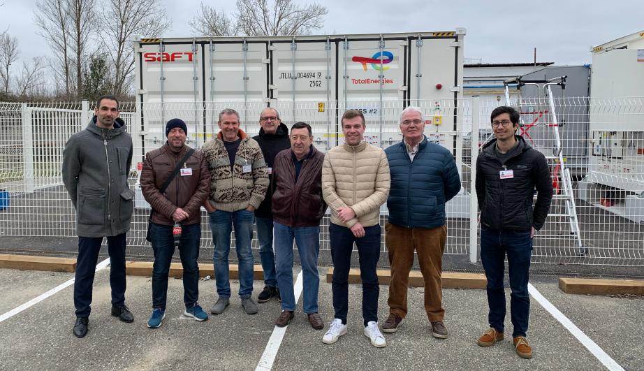 Group of people posing in a parking area - see detailed description hereafter