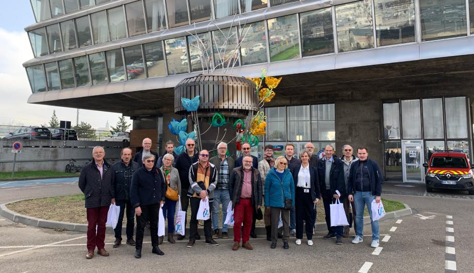Group of people posing in front of a building - see detailed description hereafter